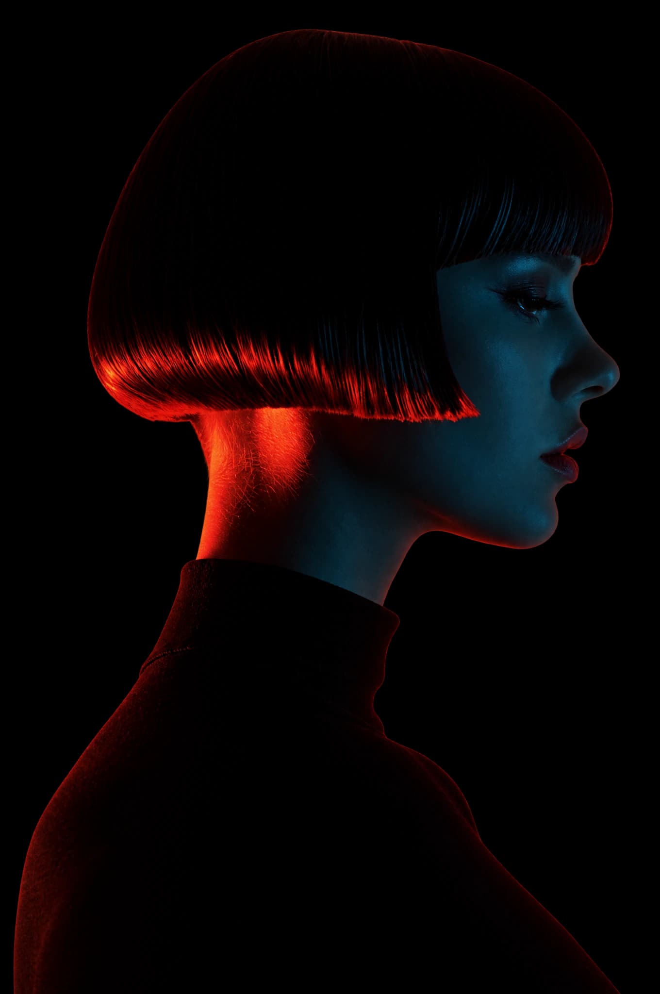 Woman in profile with a sculptural dark bob, lit in deep teal and orange